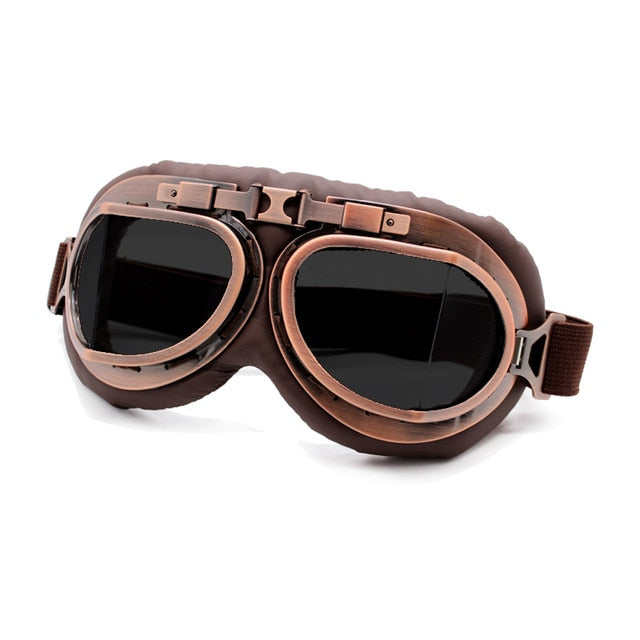 old timey motorcycle goggles dark tint lense on copper frame over tobacco leather